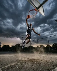 Athletic slam dunk under stormy sky