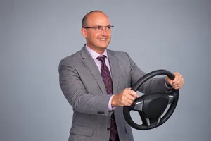 Middle aged man holding steering wheel