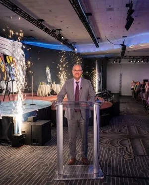 Man presenting at celebratory event stage