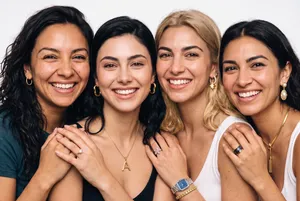 Four women smiling in close embrace
