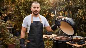 Man grilling steaks in a garden