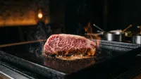 Wagyu steak searing on hot iron grill