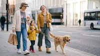 Happy family walking dog downtown