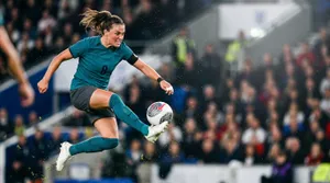 Intense female soccer player mid-air strike